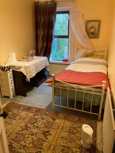 sypialnia z łóżkiem, stołem i oknem w obiekcie Country Mill House w mieście Lawrencetown