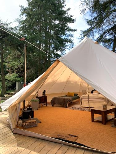 a large white tent sitting on a wooden deck at North Lodge Glamping in Carnwath