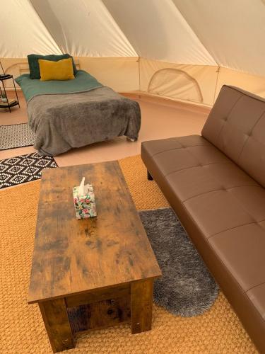 a living room with a couch and a coffee table at North Lodge Glamping in Carnwath