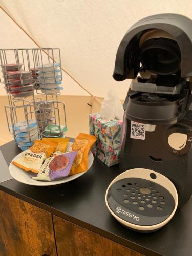 a coffee maker sitting on a counter with a plate of food at North Lodge Glamping in Carnwath