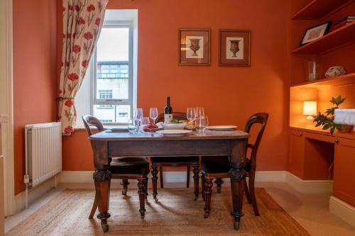 a dining room with a table with wine glasses at Chez Nous - central Maisonette - Bath Surrounds in Bradford on Avon