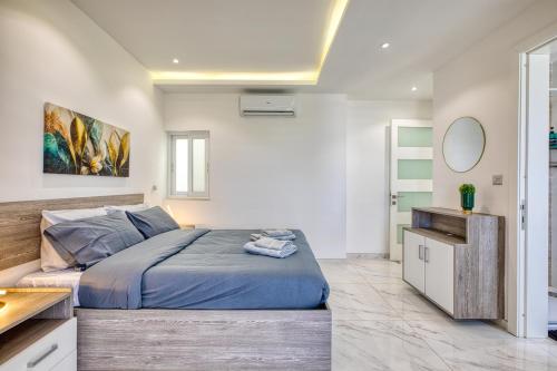 a bedroom with a large bed and a mirror at The Marylou penthouse in Mġarr
