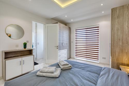 a bedroom with a large bed with towels on it at The Marylou penthouse in Mġarr