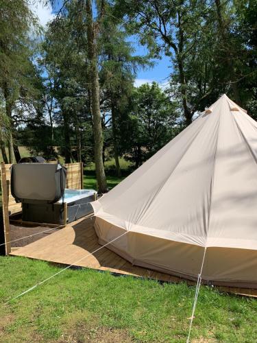 a large tent and a hot tub in the grass at North Lodge Glamping in Carnwath
