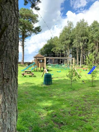 a park with a playground and a play structure at North Lodge Glamping in Carnwath