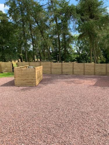 a wooden box sitting on top of a gravel field at North Lodge Glamping in Carnwath