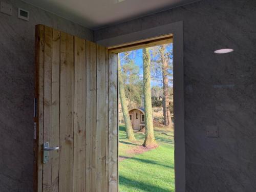 an open door with a view of a yard at North Lodge Glamping in Carnwath