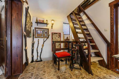 a room with a staircase and a chair in it at Casa cu Amintiri - Authentic Cozy Cottage in Bran