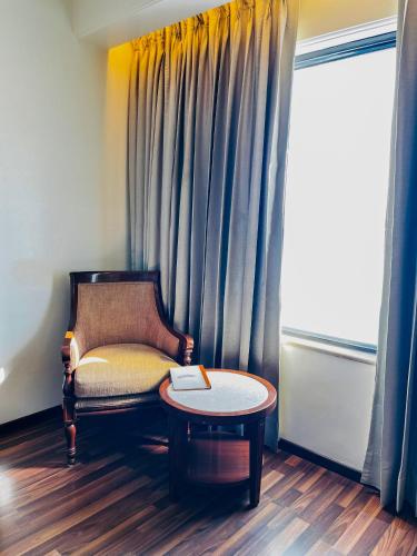 a chair and a table in a room with a window at Hotel Home In By Amrik Sukhdev in Sonīpat
