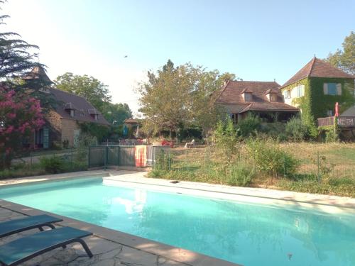 une piscine avec deux chaises à côté d'une maison dans l'établissement Gites du Mas Davet, à Miers