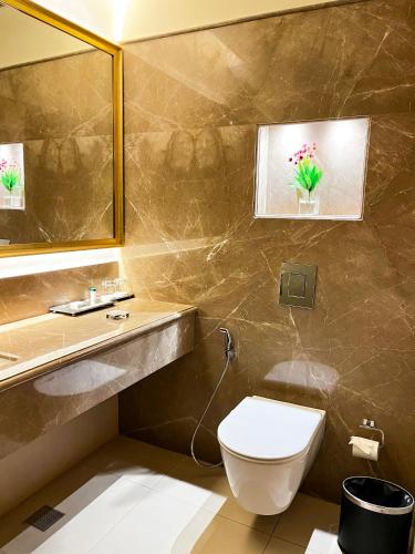 a bathroom with a toilet and a sink and a mirror at Hotel Home In By Amrik Sukhdev in Sonīpat