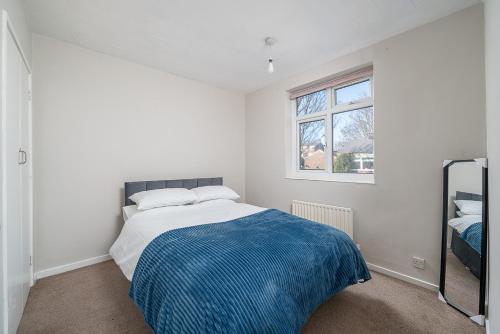 a white bedroom with a bed and a window at Stylish 3 Bed Home with Gardens Fast Transport Links in London