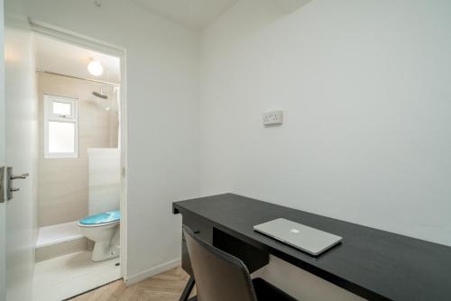 a bathroom with a desk with a laptop on it at Stylish 3 Bed Home with Gardens Fast Transport Links in London