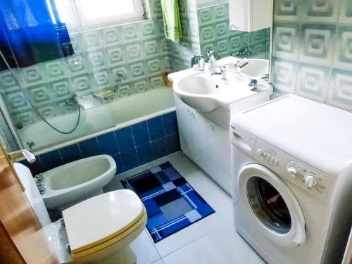 un bagno con un lavandino del water e una lavatrice di Piccola Oasi a Cannobio