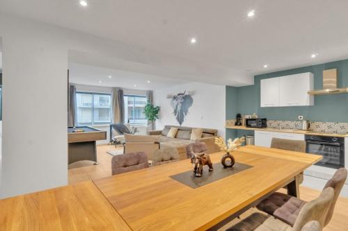 Il dispose d'une cuisine et d'un salon avec une table et des chaises en bois. dans l'établissement Le quatre sansCuls - Proche gare, à Chambéry