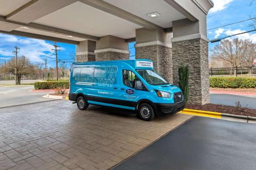 a blue van parked in front of a building at Hampton Inn & Suites Charlotte-Airport in Charlotte