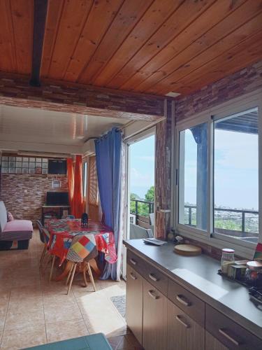 cocina y comedor con mesa y ventanas en Appartement Le Papangue, en Saint-Paul