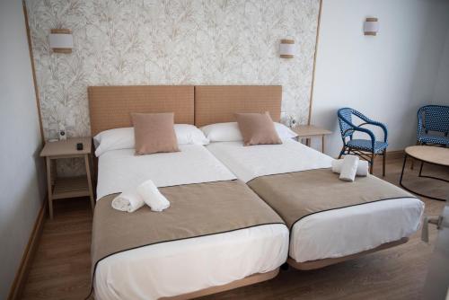 a bedroom with two beds and two chairs at Moon Dreams Noja in Noja