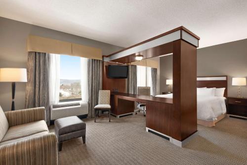 a large hotel room with a bed and a desk at Hampton Inn & Suites - Mansfield in Mansfield
