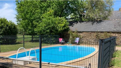 une piscine entourée d'une clôture dans l'établissement FEREL Longère near beaches, 12 people, heated pool, à Férel