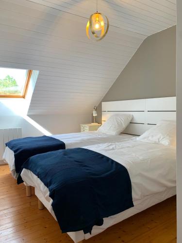 une chambre avec un grand lit avec une couverture bleue dans l'établissement FEREL Longère near beaches, 12 people, heated pool, à Férel