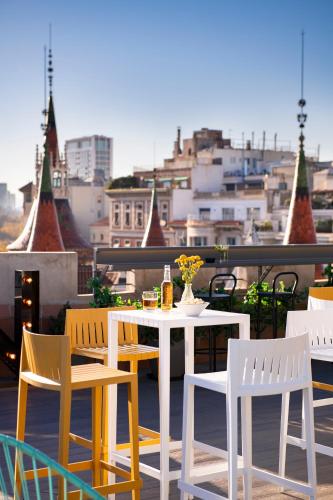 a table and chairs on a balcony with a view at Occidental Diagonal 414 in Barcelona