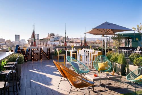 a patio with chairs and tables and an umbrella at Occidental Diagonal 414 in Barcelona