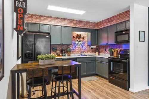 a kitchen with green cabinets and a table with stools at Cozy Condo by Music Row Walk to Restaurants and Bars in Nashville