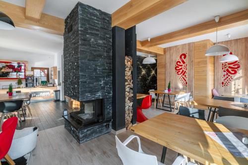 a living room with a fireplace and a table and chairs at Parzenica B&B - Wyjątkowa i Jedyna!!! Sprawdź nas a nie pożałujesz! in Białka Tatrzanska