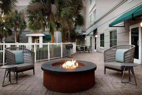 a fire pit in the middle of a courtyard with chairs at Homewood Suites by Hilton Orlando Airport in Orlando
