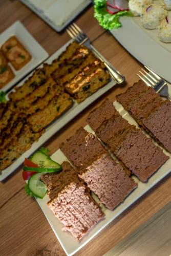 a table with a bunch of brownies and a plate of food at Parzenica B&B - Wyjątkowa i Jedyna!!! Sprawdź nas a nie pożałujesz! in Białka Tatrzanska