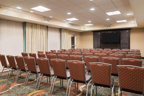 a conference room with rows of chairs and a screen at Homewood Suites by Hilton Orlando Airport in Orlando