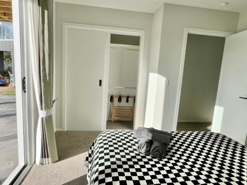 a bedroom with a black and white checkered bed at Brand new Lakeside cozy two queen rooms in Taupo