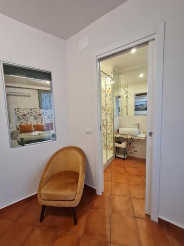 a living room with a chair and a mirror at B&B RE TANCREDI in Taormina
