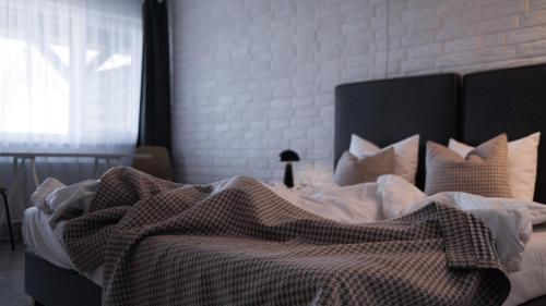 a bed with a blanket on it with a window at Łazienki Chodzieskie in Chodzież