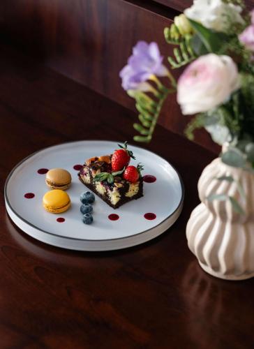 a white plate with a piece of dessert on a table at NH Budapest City in Budapest