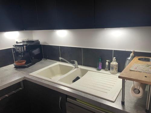 un comptoir de cuisine avec un évier et un micro-ondes dans l'établissement Maison La Rochelle lagord, à Lagord