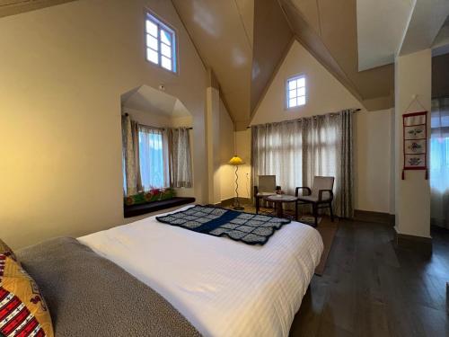a bedroom with a large bed and a table at Rang Khem - Our Home in Tawang