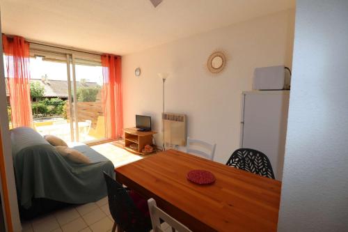 un salon avec un canapé et une table dans l'établissement 2 pièces cabine grande terrasse RDC lave-linge parking 400m plage, au Grau-du-Roi