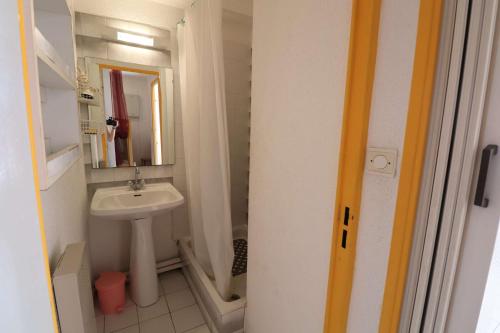 une petite salle de bain avec un lavabo et un miroir dans l'établissement 2 pièces cabine grande terrasse RDC lave-linge parking 400m plage, au Grau-du-Roi