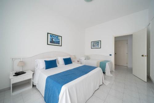 a bedroom with two beds with blue and white sheets at Hotel Panorama in Maiori