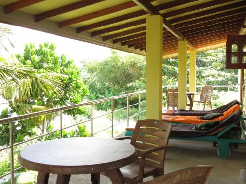 a porch with a hammock and a table and chairs at Mahi Villa in Bentota