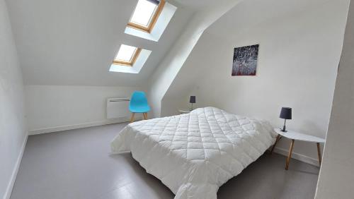 - une chambre blanche avec un lit et une chaise bleue dans l'établissement Le Voyageur A la plage vue mer, à Berck-sur-Mer