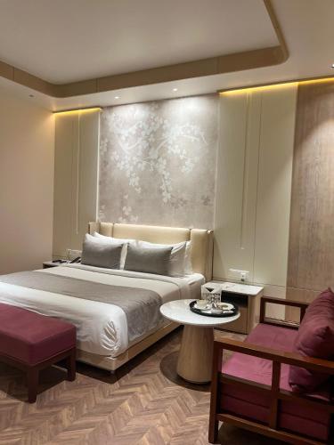 a bedroom with a bed and a table and a couch at Hotel Home In By Amrik Sukhdev in Sonīpat