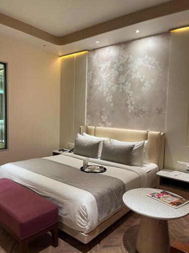 a bedroom with a large bed and a painting on the wall at Hotel Home In By Amrik Sukhdev in Sonīpat