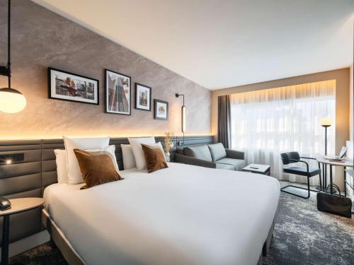 a large white bed in a hotel room at Novotel Paris La Défense Nanterre in Nanterre