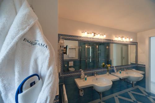 a bathroom with three sinks and a large mirror at Hotel Panorama in Maiori