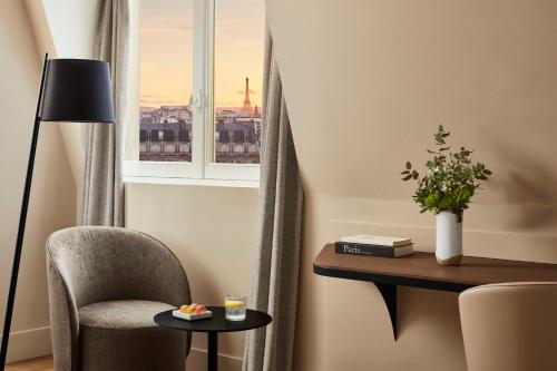 une pièce avec une chaise, une table et une fenêtre dans l'établissement NH Paris Gare de l'Est, à Paris