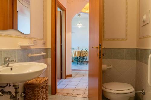 a bathroom with a sink and a toilet and a hallway at Appartamento La Quiete in Polpenazze del Garda