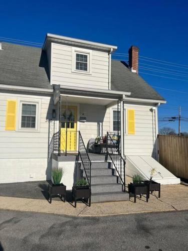 フレデリックにあるPatty's Place in Downtown Frederickの黄色のドアと階段のある白い家